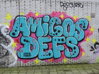 848178 Afbeelding van graffiti met de tekst 'AMIGOS - DEFS' uit 2019, op een muur langs het voetpad onder de sporen aan ...